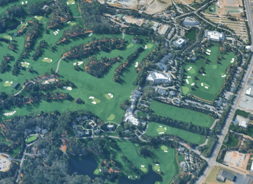 Aerial view of a real golf course with dense tree cover.